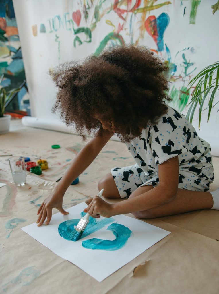 Child artist expressing creativity with bright colors in a vivid art environment. Ideal for educational and artistic themes.